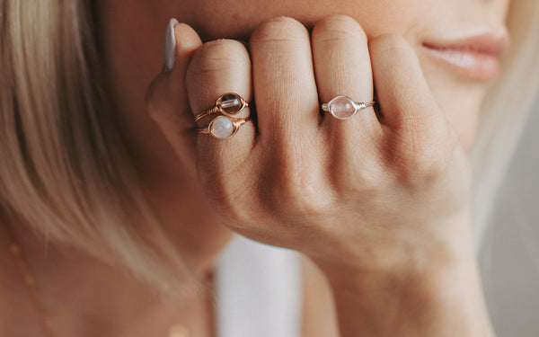 life style image of woman wearing three gemstone solitaire rings