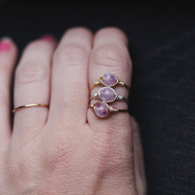 a picture of 3 lavender amethyst gemstone rings side by side displayed on a womans finger