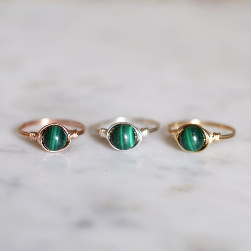 a photo of three malachite gemstone rings in gold silver and rose gold