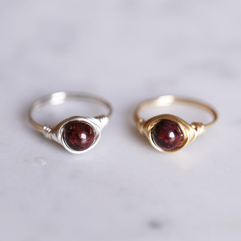 photo of two garnet gemstone solitaire rings next to eachother