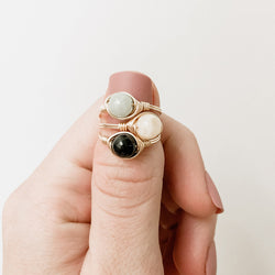 a photo of gemstone ring stacking on thumb