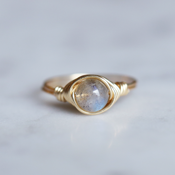 labradorite gemstone ring with band and setting made of 14k gold filled showing off beatiful blue flash from stone