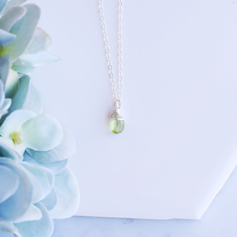 peridot gemstone necklace displayed on chain that is sterling silver